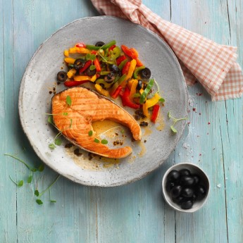 Rodaja de salmón con pimientos salteados y aceitunas negras